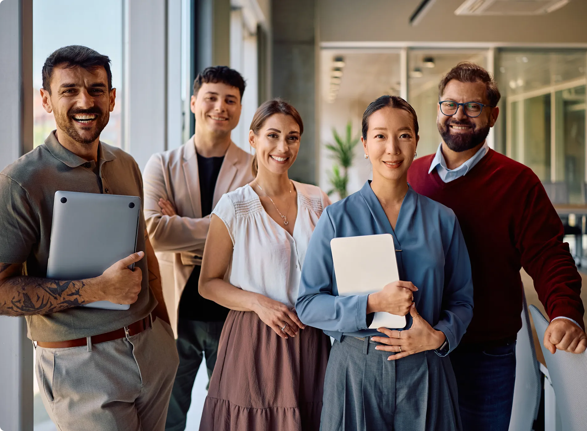 Group of professionals standing and smiling indoors.